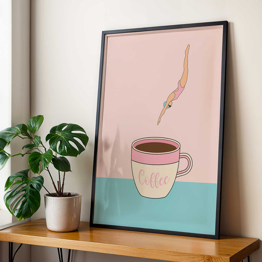 Framed artwork of a diver diving into a coffee cup with a plant on a table below.